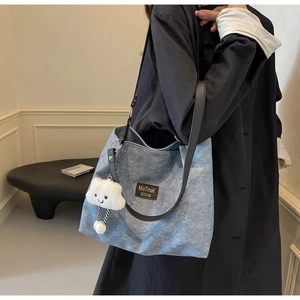 Gros plan sur un cabas en denim bleu clair avec lanières en cuir et charme de nuage