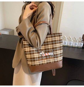 Detail of brown plaid tote bag with dog embroidery and textured faux leather shoulder strap
