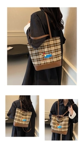 Detail of vintage plaid tote bag featuring embroidered dachshund and brown leather straps