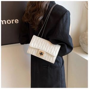 Detail of white leather chain bag with textured stripes and golden clover clasp
