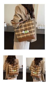 Detail of checkered tote with dog embroidery and leather base on model