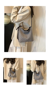 Detail of grey fabric bucket bag with black heart patterns and decorative side ribbons