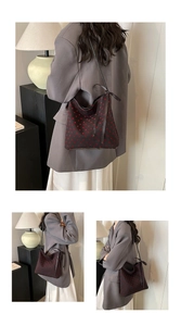 Detail view of bow ribbon closure on black bucket bag with red heart patterns