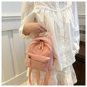 Mini macaron pink backpack in matte nylon fabric held by model for a casual look