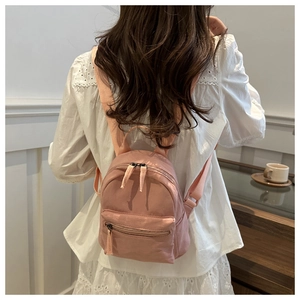 Vue arrière d'un modèle portant le mini sac à dos de voyage rose à double zip