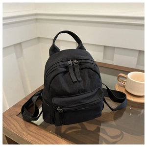 Close-up of minimalist black nylon mini backpack featuring high-quality zipper and texture