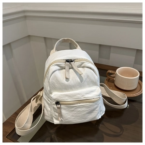 Minimalist white canvas mini backpack for women shown in a casual lifestyle setting