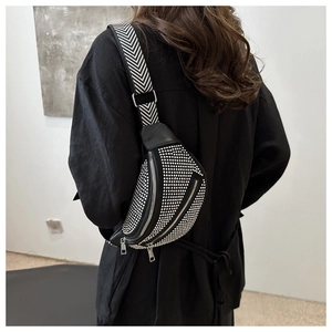 Detail of crossbody bag with silver rhinestones and chevron pattern strap
