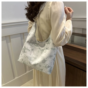Chic tote bag featuring grey butterfly prints and star patterns on a creamy canvas fabric