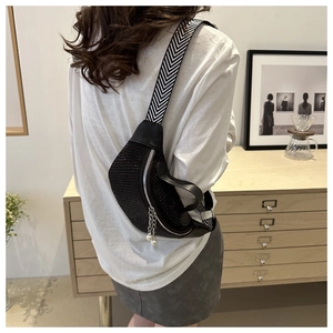 Detail of black rhinestone fanny pack with herringbone strap and pearl zipper pull