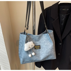 Sac cabas en denim bleu avec pendentif nuage blanc pelucheux sur un cintre en acier