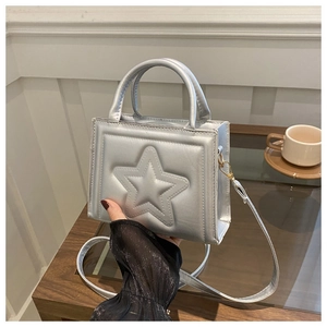 Detail of silver square handbag featuring star embossing and double top handles