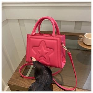 Chic fuchsia square handbag with star embossing shown in a lifestyle cafe setting