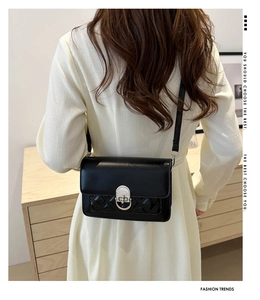 Détail du sac bandoulière matelassé noir avec fermoir circulaire argenté sur mannequin