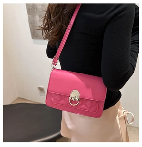 Detail of fuchsia leather crossbody bag with quilted pattern and metal ring twist lock