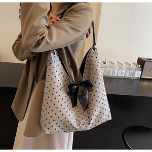 Detailed shot of grey knit tote bag with black heart dots and a large satin bow