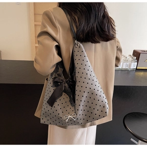 Detailed view of grey polka dot tote bag with black ribbons and fine shoulder straps