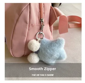 Detailed shot of a pink oxford shell bag with smooth metal zipper and star plush charm