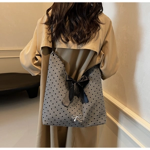 Detail of grey canvas tote bag with black heart prints and a large satin bow decoration