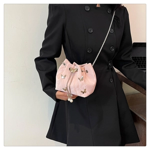 Pink drawstring bucket bag detail with silver butterfly charms and pearl pendants