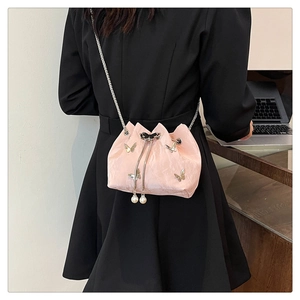 Detail of pink pleated mini bucket bag with silver butterfly charms and pearl drawstring
