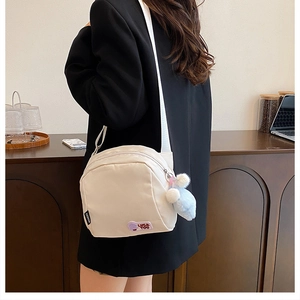 Detail of off-white nylon shoulder bag with LUCK YOU embroidery and plush ball charm