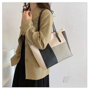 Detail of multi-color patchwork tote bag with gold metal buckle and adjustable strap