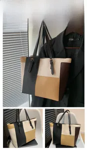Detail view of large color-block tote bag with adjustable straps and metal buckles