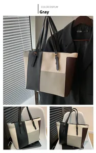 Detail view of large color-block tote bag with adjustable shoulder strap and metal buckle