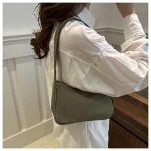 Olive green suede underarm bag shown on model for a minimalist chic shoulder carry style