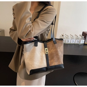Close-up of contrast color tote bag with vintage metal buckle and long shoulder strap