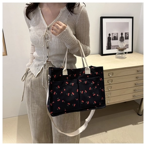 Détail du sac cabas en nylon à fleurs avec cerises, poches avant et bandoulière