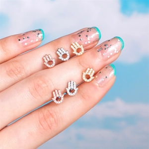 Detailed close-up of Hamsa Hand ear studs with cubic zirconia in gold and silver finish