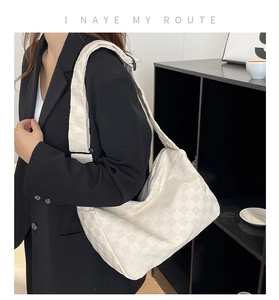 Gros plan du sac hobo à carreaux blancs avec texture en tissu épais et large bandoulière