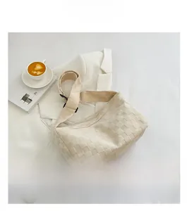 Détail du sac dumpling matelassé blanc cassé avec bandoulière réglable sur veste