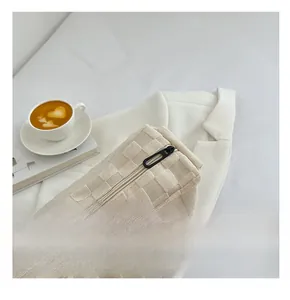 Détail de la fermeture éclair noire fluide sur un sac à main en tricot à carreaux