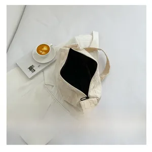 Vue de dessus de l'intérieur spacieux du sac tressé crème avec fermeture éclair noire