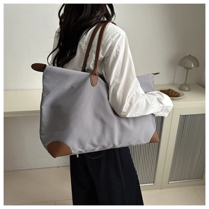 Vista laterale dettagliata di una borsa tote grande in tessuto Oxford viola e pelle