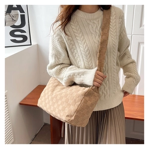 Détail du grand sac cabas tressé beige avec texture damier et bandoulière large