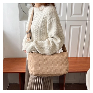 Detail view of khaki checkered crossbody bag featuring a textured grid pattern and strap