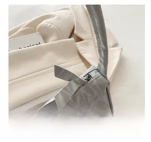 Detail of light gray shoulder bag showing unique marble texture and smooth silver zipper