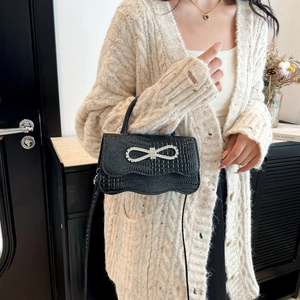 Elegant black crocodile pattern handbag with rhinestone bow and wavy edge design