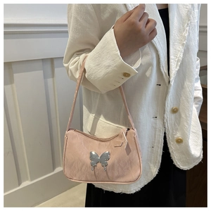 Detail of light pink shoulder bag with metallic butterfly and pleated texture