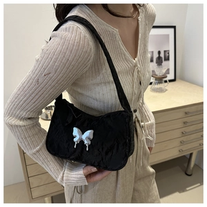Close-up of black pleated underarm bag with metallic silver butterfly decoration