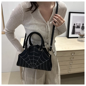 Fashionable black spider web crossbody bag with white stitching and geometric shape