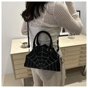 Detailed embroidery of white spider web on black leather handbag for Halloween style
