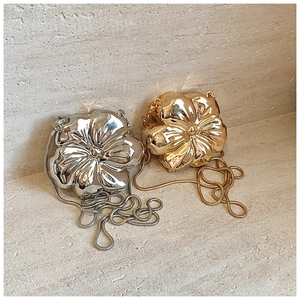 Close-up of metallic flower-shaped mini bags with high-gloss mirror finish and chain straps