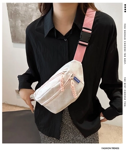 Detail of pink and white textured crossbody bag with dual zippers and fashion label