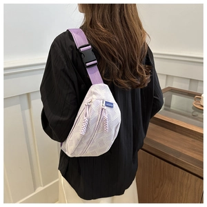 Detail showing lavender quilted texture fabric and woven fashion label on the crossbody bag
