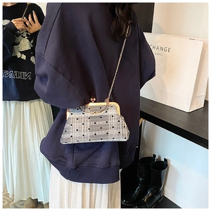 Close-up of retro grey mesh handbag with black polka dots and metal ring handle